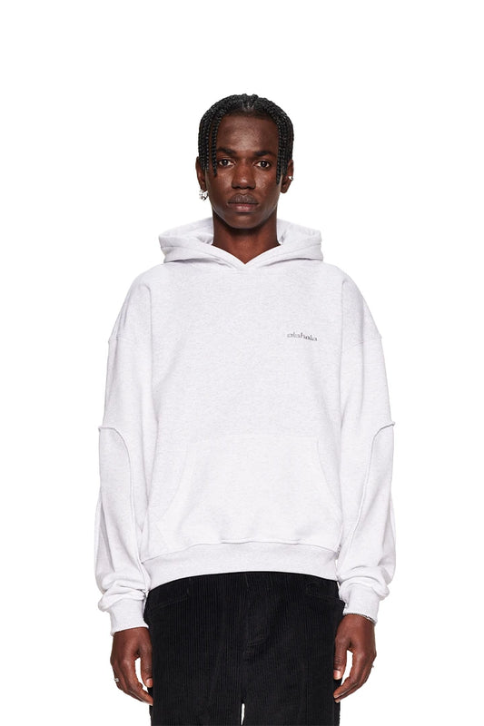 Man wears grey CC Essential hoodie with embroidered OLAKALA logo on the chest, ribbed cuffs and hem, oversized fit.