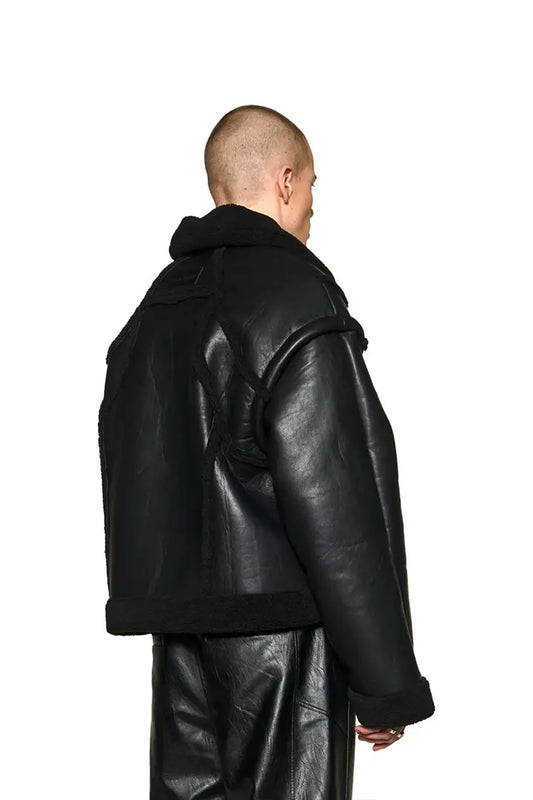 Anatomy Shearling Leatherjacket mit abnehmbaren Ärmeln, Eingriffstaschen, gesticktem OLAKALA-Logo, Reißverschlusstasche und geprägtem Patch, präsentiert von einem Mann getragen.