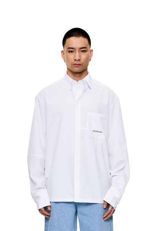 Unisex CC Button Shirt White mit doppeltem Kragen und aufgesetzter Brusttasche, oversized Passform, Metall-Logo auf der Brusttasche, sichtbare Teilungsnähte.