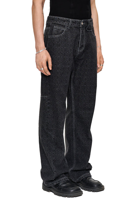 Person wears CC Black Monogram Denim Pants with an offset waistband and OLAKALA patch, the loose fit and the striking monogram design are visible.