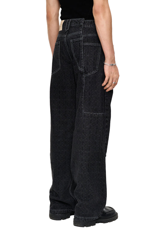 Person wears CC Black Monogram Denim Pants with offset waistband and