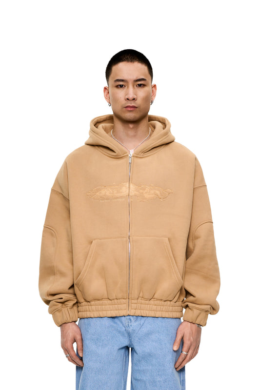 CC Zip Hoodie Beige, getragen von einem Mann, mit Reißverschluss, Kängurutasche und elastischen Bündchen. OLAKALA Logo auf der Brust sichtbar.