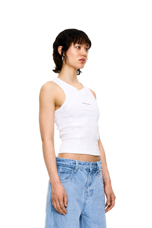Woman wears CC Anatomy Tank Top Cropped White with decorative stitching and embroidered OLAKALA logo, emphasizes tight fit.