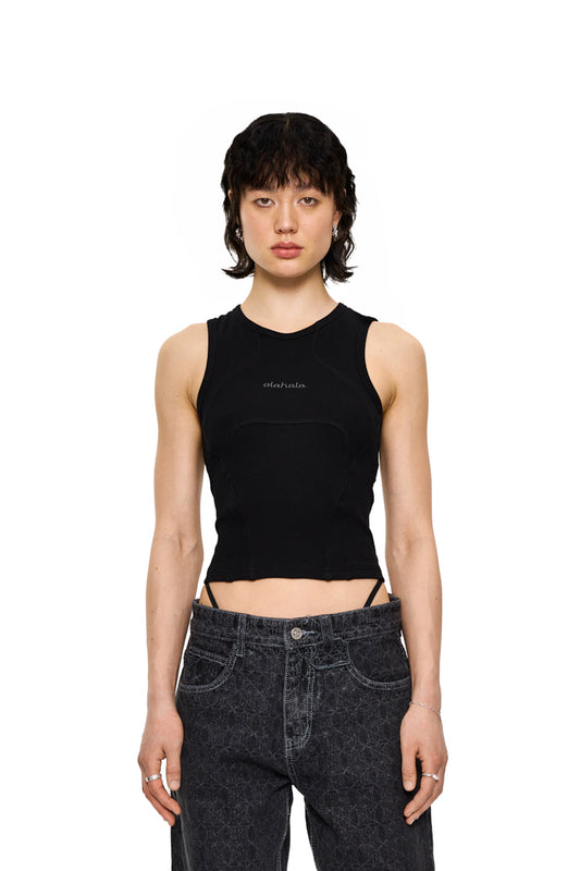 Frau trägt das CC Anatomy Tanktop Cropped Black mit Ziernähten und gesticktem OLAKALA Logo, das eng anliegt und unisex ist.