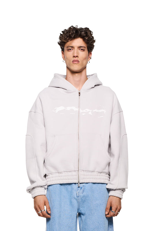 Mann trägt Elysium Zip Hoodie Light Gray mit 2-Wege-Reißverschluss, Teilungsnähten und Elysium-Grafik. Oversized Passform und elastische Bündchen sichtbar.