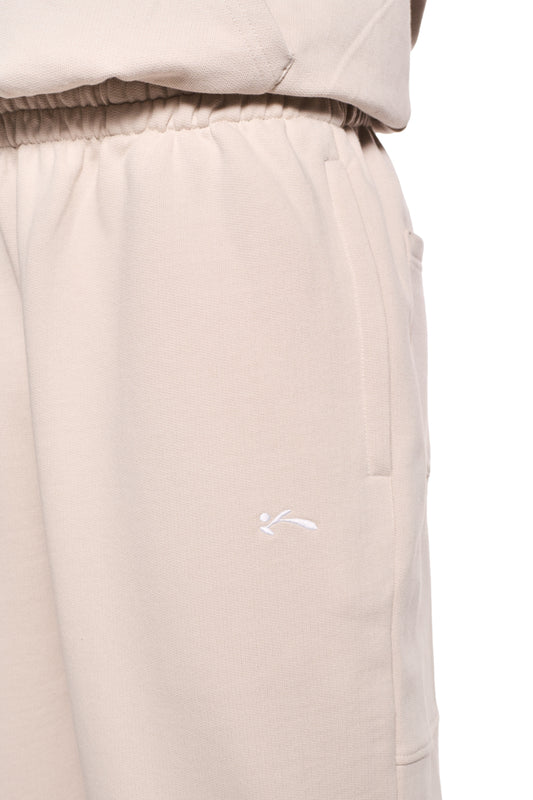 Sports Sweatpants Beige mit Reißverschlusstaschen, elastischem Bund und Bündchen, versetzter Gesäßtasche und gesticktem OLAKALA Sports Icon auf der Vorderhose.
