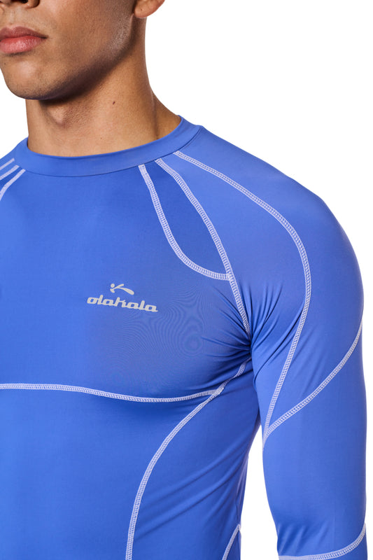 Man wears OLAKALA Sports Anatomy Tech Top Blue with logo on chest, close-fitting cut and long sleeves.