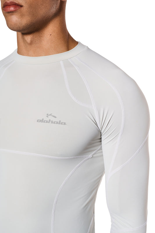 Man wears the Sports Anatomy Tech Top Gray with OLAKALA Sports logo on the chest, accentuated by decorative stitching and a tight fit.