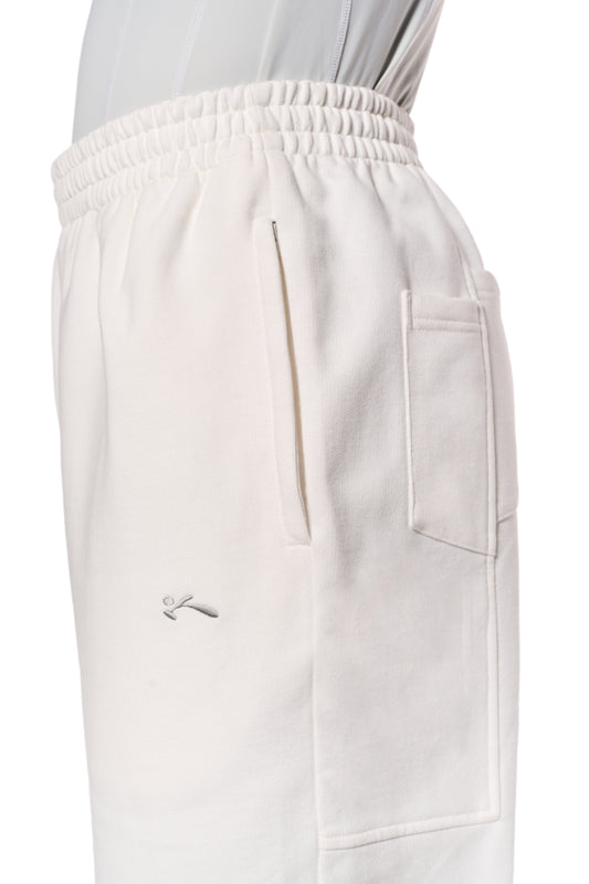 Weiße Sports Sweatpants mit Reißverschlusstaschen, elastischem Bund und Kordelzug. Lockere Passform, gesticktes OLAKALA Sports Icon vorne links. Unisex-Design.