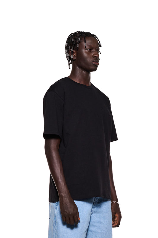 Mann im schwarzen NC T-Shirt mit OLA KALA Logo auf der Brust und Grafik auf dem Rücken, Nahaufnahme der Hand. Unisex, Regular Fit.