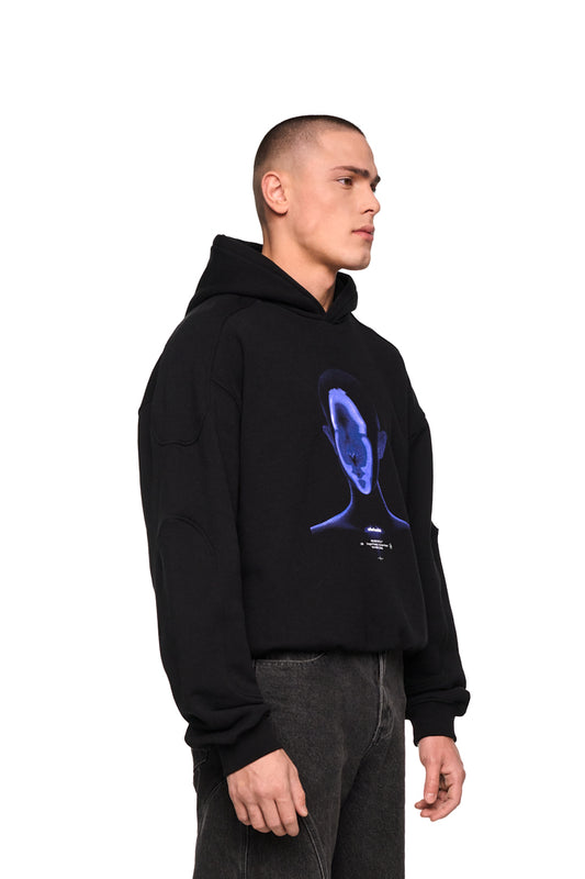Mann trägt Alien Intel Mask Hoodie Blue mit grafischem Siebdruck, Ripp-Bündchen und elastischem Saum, zeigt oversized unisex Design mit markanten Teilungsnähten.