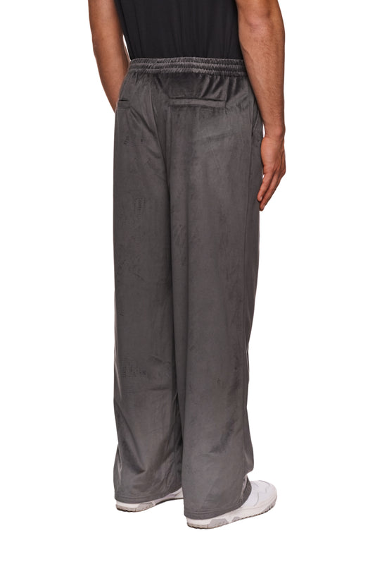Person trägt graue Sports Velour Jogger Pants mit offenem Beinabschluss, Eingriffstaschen und gesticktem OLAKALA-Logo, lockere Passform.