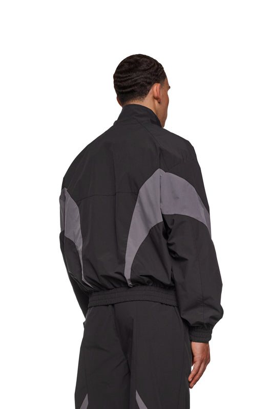 Sports Trackjacket Black aus robustem Rip-Stop-Gewebe, mit atmungsaktivem Mesh-Futter, elastischen Bündchen und gesticktem OLAKALA-Logo auf der Brust, rückseitige Ansicht.