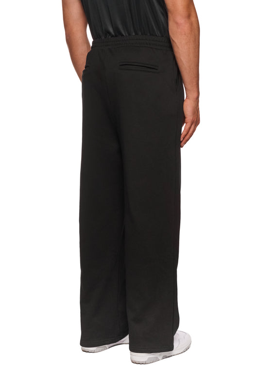 Person trägt OLAKALA Sports Loose Fit Sweatpants mit lockerem Schnitt, elastischem Bund und gesticktem Logo. Ideal für entspannten, komfortablen Look.