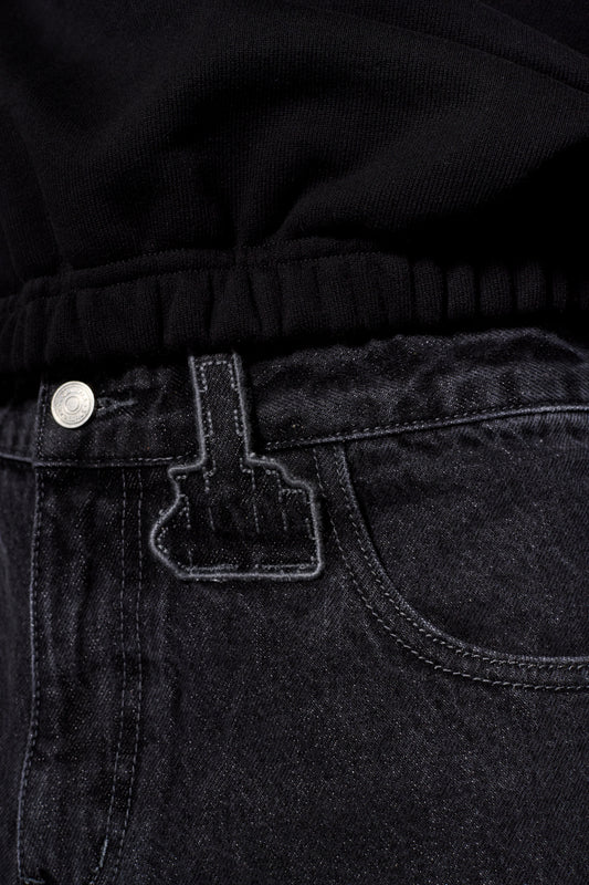 Nahaufnahme der CC Black Denim Pants Baggy mit 5-Pocket-Design, versetzter Seitennaht und gesticktem OLAKALA Logo.