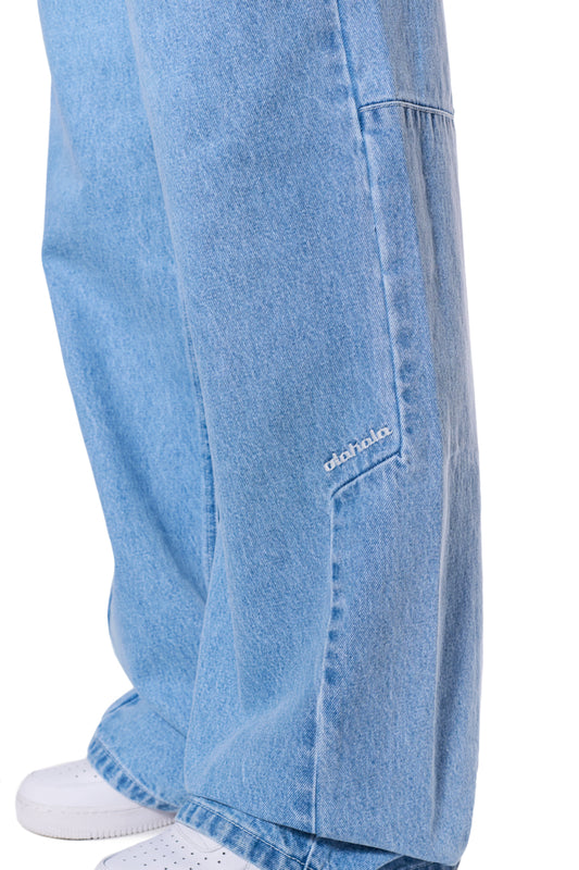 Close-up of the CC Blue Loose Fit Denim Pants with offset waistband and embroidered OLAKALA logo on the left front pant, made of 14 oz denim.