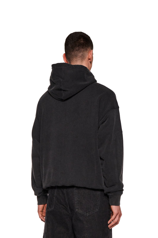 Mann trägt E.O.I Hoodie Black mit Kängurutasche und Siebdruck-Grafik, betont durch Ripp-Bündchen und Teilungsnähte, präsentiert lockeren Unisex-Stil.