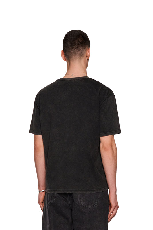 Mann trägt E.O.I. T-Shirt Schwarz mit Ripp-Kragen und Siebdruck-Grafik; zeigt Rückansicht und Jeans. Unisex, reguläre Passform.