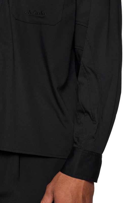 CC Anatomy Shirt Black, close-up shows button placket, double-layer collar, breast pocket with embroidered OLAKALA logo and dividing seams. Unisex and loose fit.
