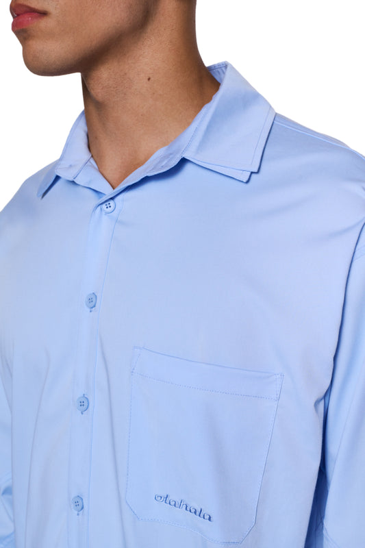 Nahaufnahme des CC Anatomy Shirt Blue mit Knopfleiste, aufgesetzter Brusttasche und gesticktem OLAKALA-Logo. Lockerer Schnitt, unisex Design.