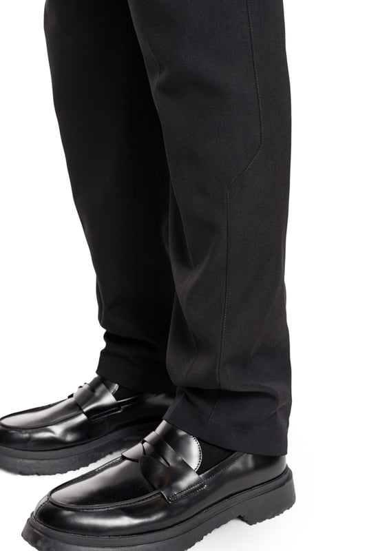 Nahaufnahme von CC Dress Pants Slim Fit Black mit asymmetrischer Tasche, Paspeltaschen hinten, Bundfalten und gesticktem OLAKALA Logo über der rechten Gesäßtasche.