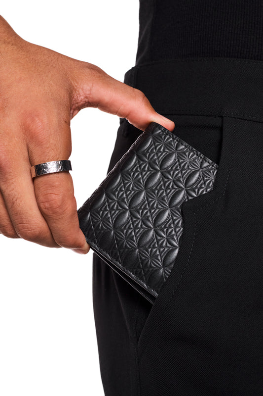 Person hält das CC Monogramm Wallet mit OLAKALA-Prägung, zeigt 6 Kartenfächer und ein Geldscheinfach, im Fokus die Hand mit Ring und silbernem Armband.