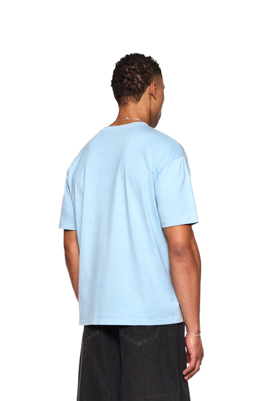 Mann trägt Fusion T-Shirt Blau mit Ripp-Kragen und Grafik-Siebdruck auf der Brust, reguläre Passform, unisex. Produkt von OLAKALA.