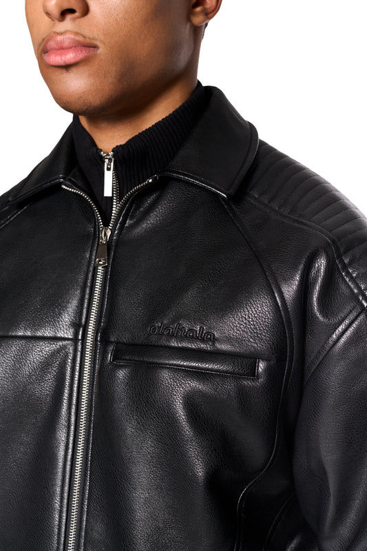 Close-up of the CI Leather Jacket Black made of vegan faux leather with padded shoulders, zipper and OLAKALA logo on the chest.