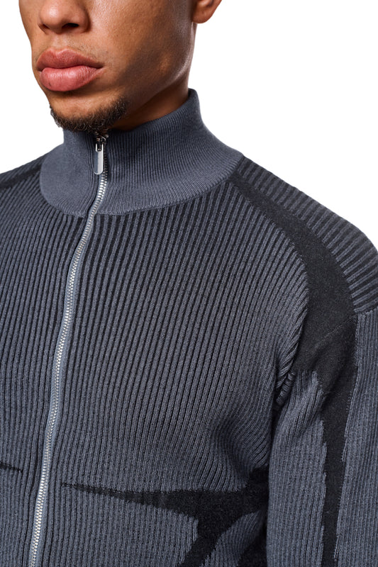 Nahaufnahme eines Mannes, der eine Luminous Zip Jacket Gray trägt, mit hohem Kragen, gestricktem Muster und elastischen Bündchen, im offiziellen OLAKALA® Onlineshop erhältlich.