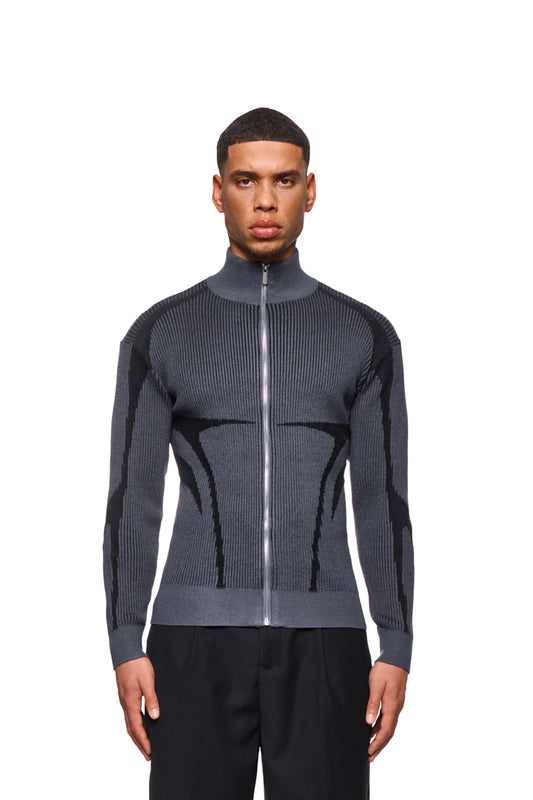 Mann trägt Luminous Zip Jacket Gray mit hohem Kragen, elastischen Bündchen und gestricktem Muster.