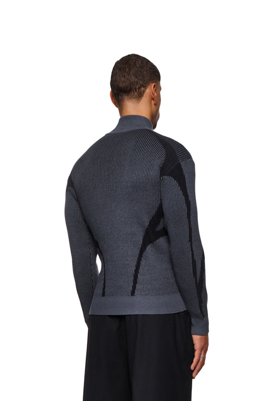 Mann trägt Luminous Zip Jacket Gray mit hohem Kragen, gestricktem Muster und elastischen Bündchen, gezeigt von hinten. Unisex-Design, reguläre Passform.
