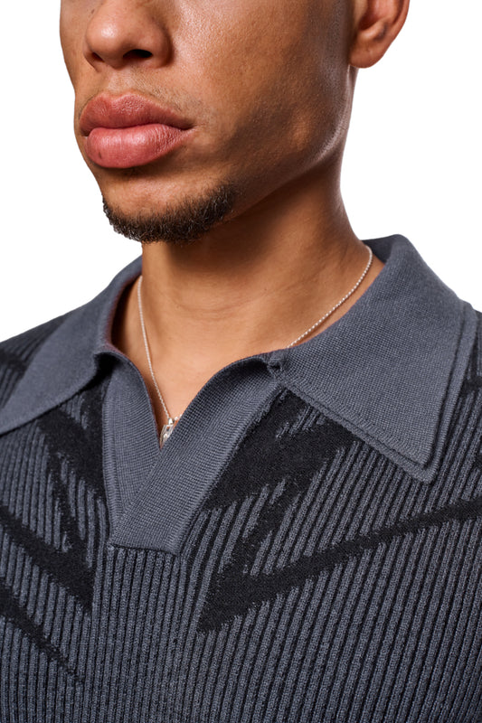 Close-up of a man with a polo collar without a button, knitted pattern and elasticated cuffs. Loose, unisex cut of the Luminous Polo Gray.
