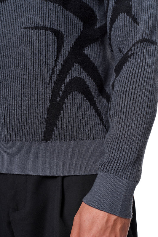 Person wears a gray Luminous polo with knitted pattern, polo collar without button, elastic cuffs and hem. Unisex, loose fit.