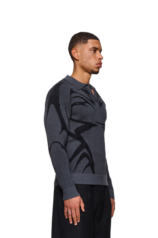 Man wears Luminous Polo Gray with knitted pattern, polo collar without button and elastic cuffs. Loose, unisex cut, presented by OLAKALA.