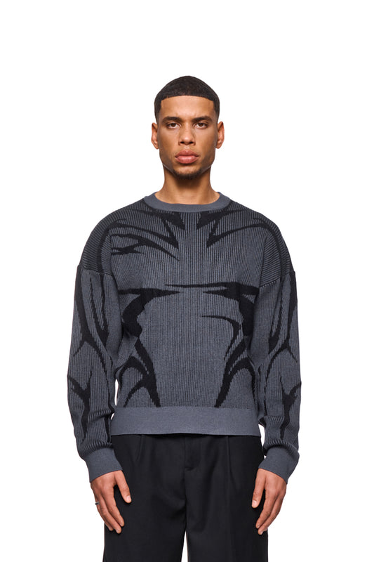 Man wears Luminous Sweater Gray with knitted pattern and elastic cuffs, loose fit, unisex. Perfect for casual outfits from OLAKALA.