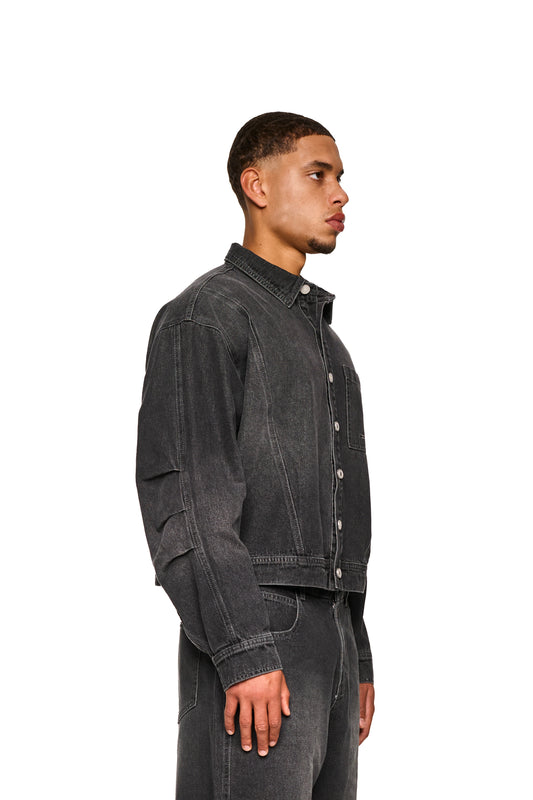 Nahaufnahme des 0asis Denim Overshirt Black mit gefalteten Ärmeln, aufgesetzten Brusttaschen und geprägtem OLAKALA-Patch, ideal für kühlere Sommertage.