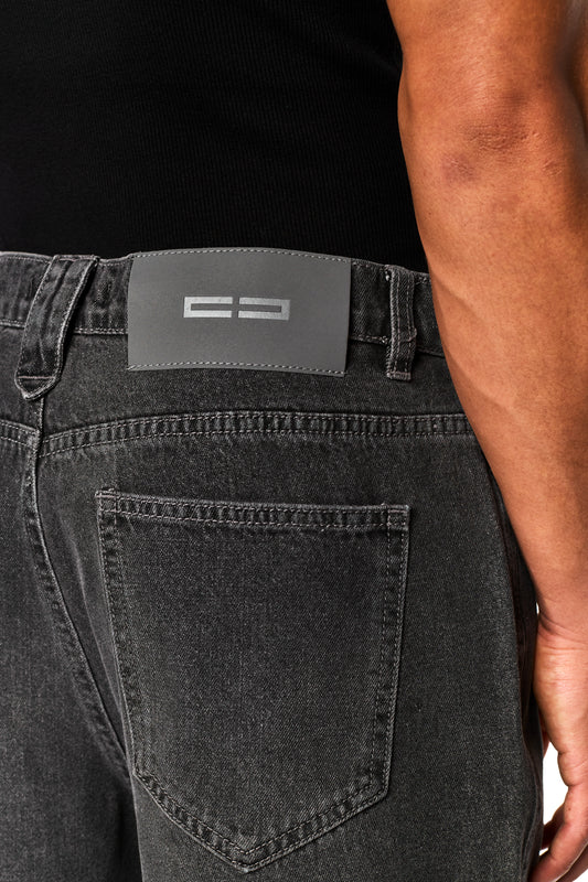 Nahaufnahme von 0asis Denim Shorts Black mit 5-Pocket-Design, versetzter Passe, aufgesetzter Tasche, OLAKALA-Patch und Logo-Stickerei auf dem Hosenbein.