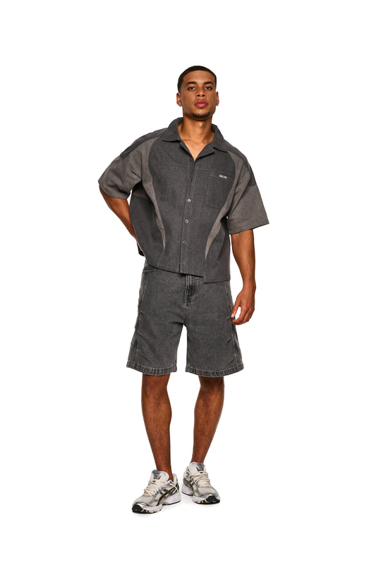 Ein Mann trägt Echoes Jorts Gray und graues Shirt, betont die lässige Eleganz der OLAKALA® Kollektion. Nahaufnahme des Schuhs und der Shorts.