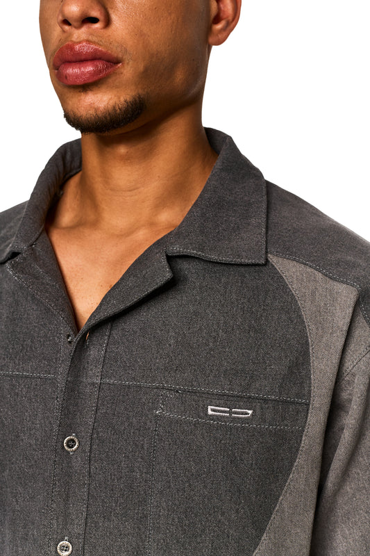 Nahaufnahme des Echoes Denim Icon Shirt Gray mit sichtbarem Kragen und Knopf, getragen von einer Person, passend zum stilvollen Sortiment des offiziellen OLAKALA® Onlineshops.