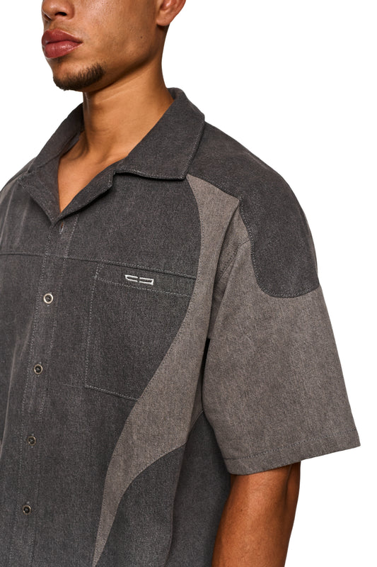 Nahaufnahme eines Mannes, der das Echoes Denim Icon Shirt Gray trägt, mit Fokus auf den Kragen und die Details des Hemdes.
