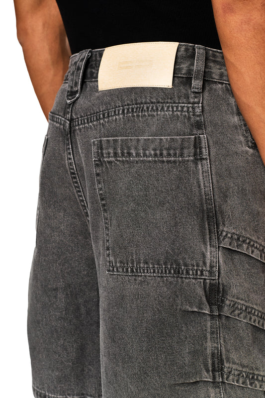 Nahaufnahme eines Arms und Beins mit Echoes Jorts Gray Jeans, die lässigen Stil und Denim-Details zeigen. Perfekt für den offiziellen OLAKALA® Onlineshop.