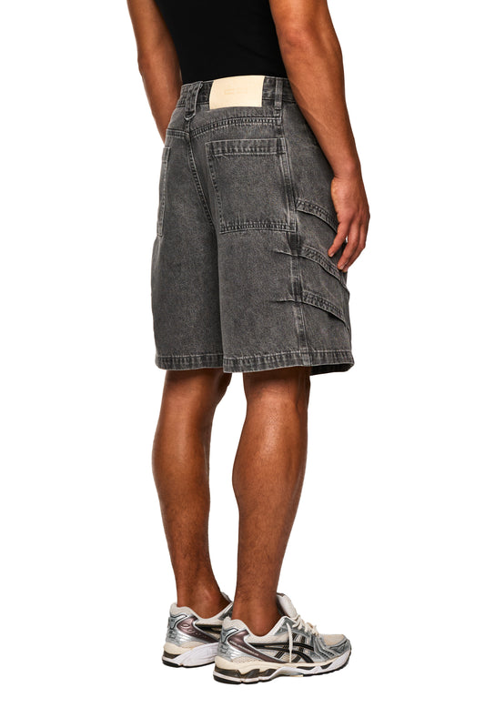 Mann trägt Echoes Jorts Gray, fokussiert auf Beine und Schuhe, kombiniert mit Shorts aus der OLAKALA Kollektion.
