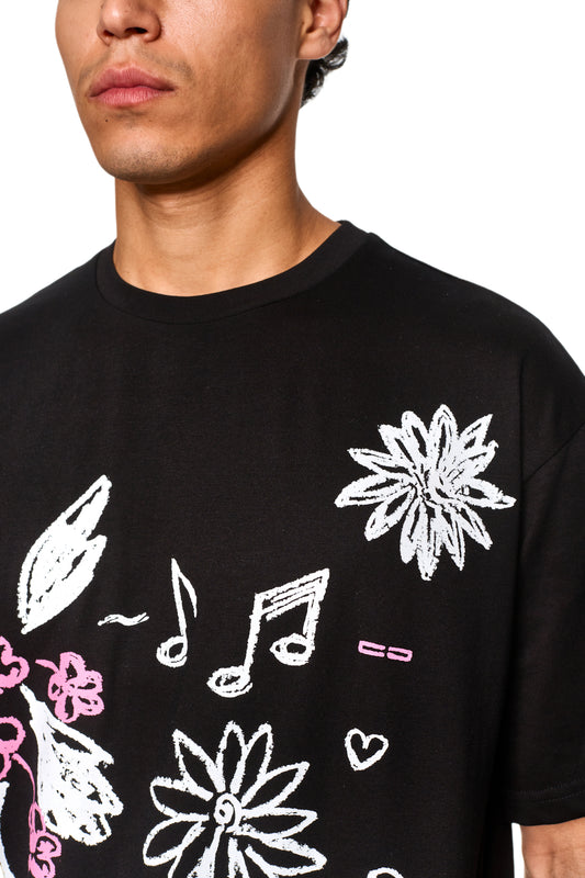 Nahaufnahme eines Mannes, der ein Crayon T-Shirt Oversized Black trägt, das die Details des Kragens und den oberen Teil des Shirts zeigt.