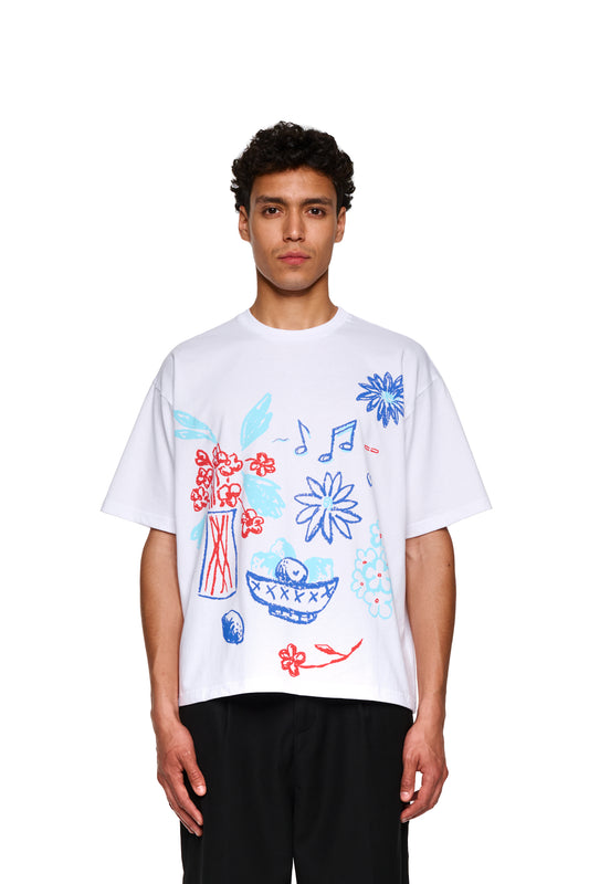 Mann trägt OLAKALA® Crayon T-Shirt Oversized White mit Zeichnungen, Nahaufnahme des Gesichts und Oberkörper im weißen Shirt.