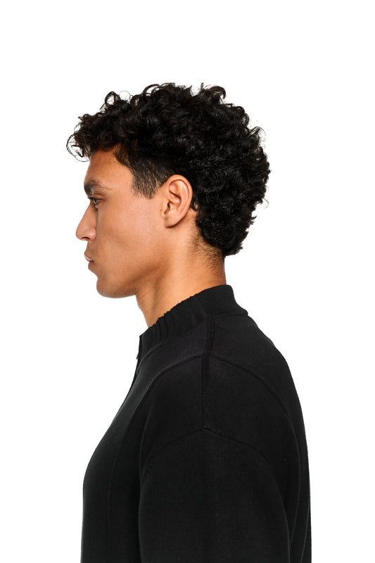 Nahaufnahme des Summer Knit Jacket Black mit asymmetrischer Vorderseite, aus weichem Baumwollstrick und Rippenmuster, geeignet für warme Sommerabende.
