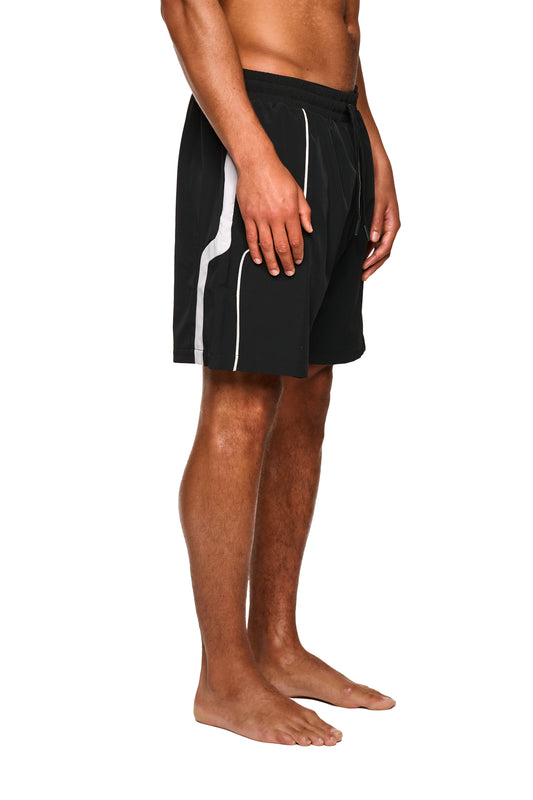 Nahaufnahme der 0asis Swim Shorts Black mit Mesh-Innenfutter und Kontrasteinsätzen, lockerem Schnitt und Logo-Print auf dem linken Bein.