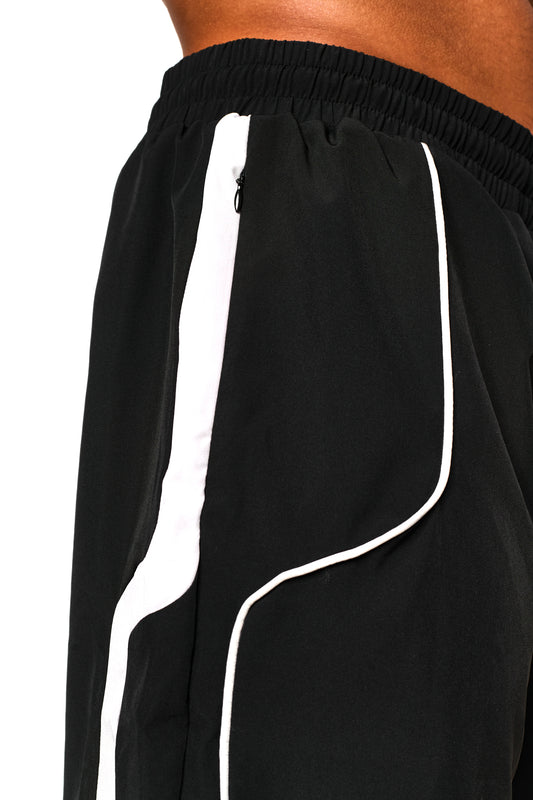 Nahaufnahme von 0asis Swim Shorts Black mit kontrastreichen Einsätzen, Mesh-Innenfutter und silikonbeschichteten Kordelzügen, ideal für Bewegungsfreiheit am Pool oder Strand.
