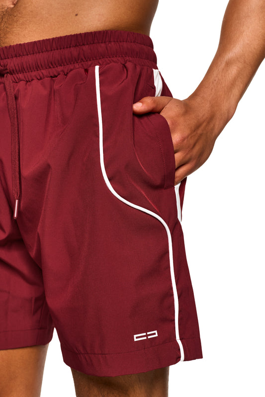 Hand in Tasche der 0asis Swim Shorts Red, zeigt elastisches Material und Seitentasche mit Reißverschluss, ideal für Bewegungsfreiheit am Pool oder Strand.