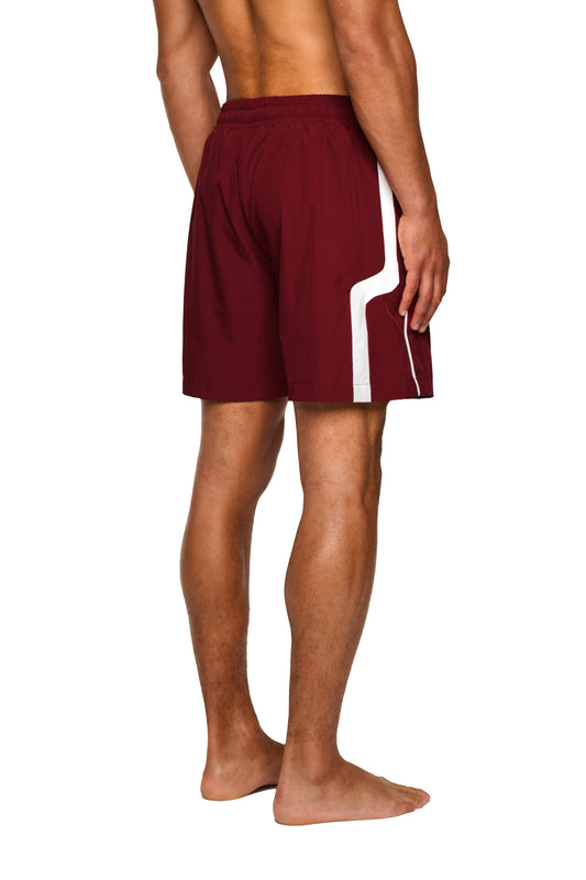 Nahaufnahme der 0asis Swim Shorts Rot mit elastischem Material, Mesh-Innenfutter und Silikon-Kordelzügen, getragen von einer Person, die Bewegungsfreiheit am Pool oder Strand genießt.
