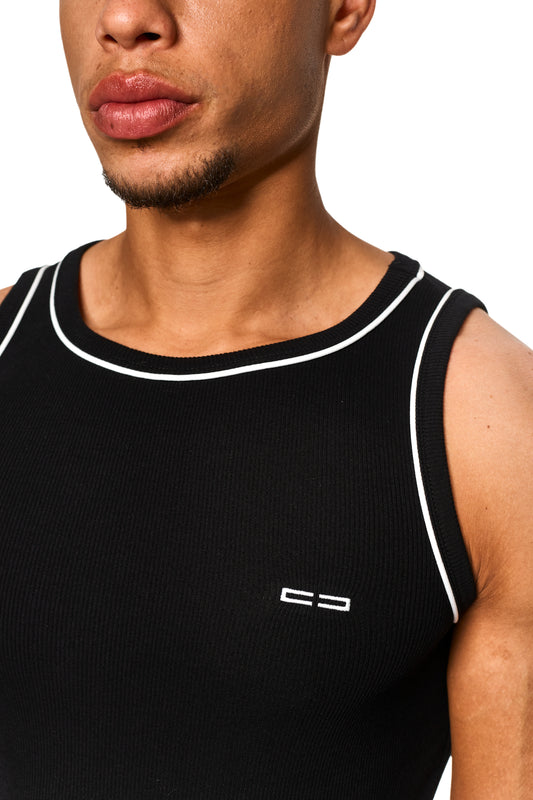 Nahaufnahme eines Unisex Contrast Tanktop Black mit elastischem Ripp-Stoff, kontrastierenden Paspellierungen und gesticktem OLAKALA Icon auf der linken Brust.